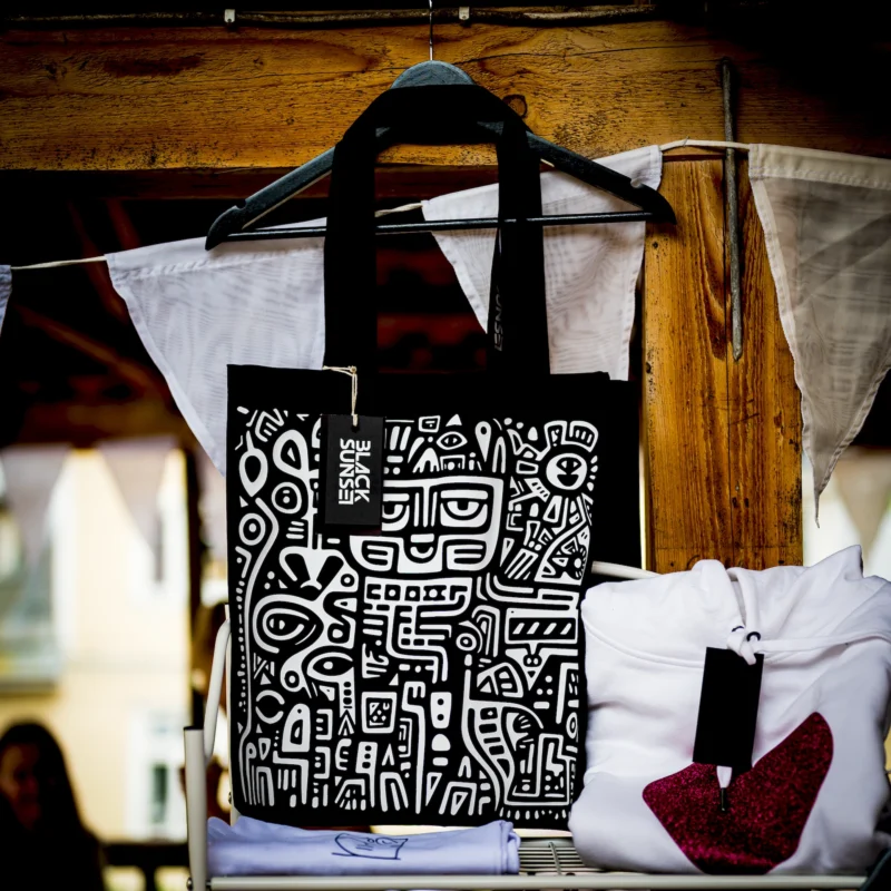 Blacksunseti must-valge graafilise mustriga tote kott, riputatud väljapanekule Tartu Disainipäeval.
