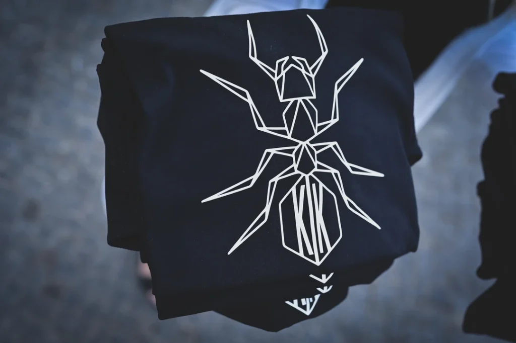 Blacksunset mustad T-särgid geomeetrilise sipelga trükiga – virnas; valge line-art front-print, detailne graafika.