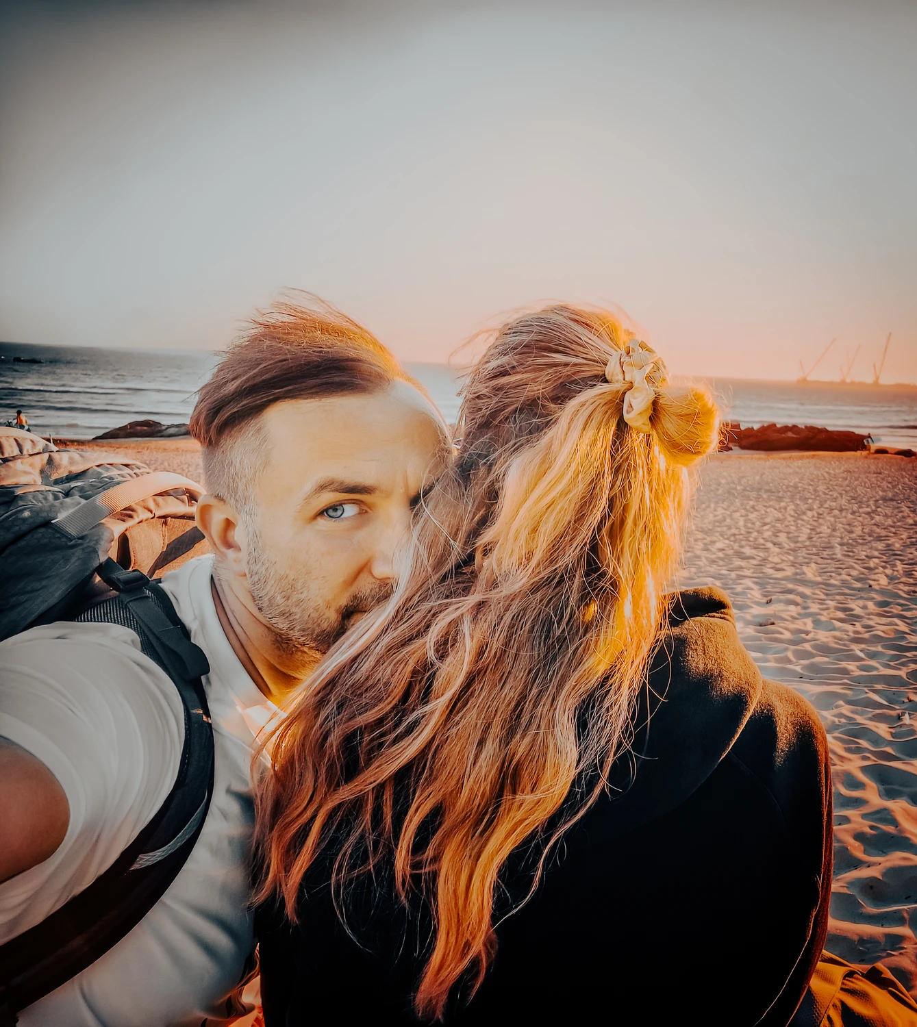 Paar rannal kuldses loojangus; lähiplaan õlg-õla kõrval – soe toon ja vabaaja meeleolu, Blacksunset lifestyle.