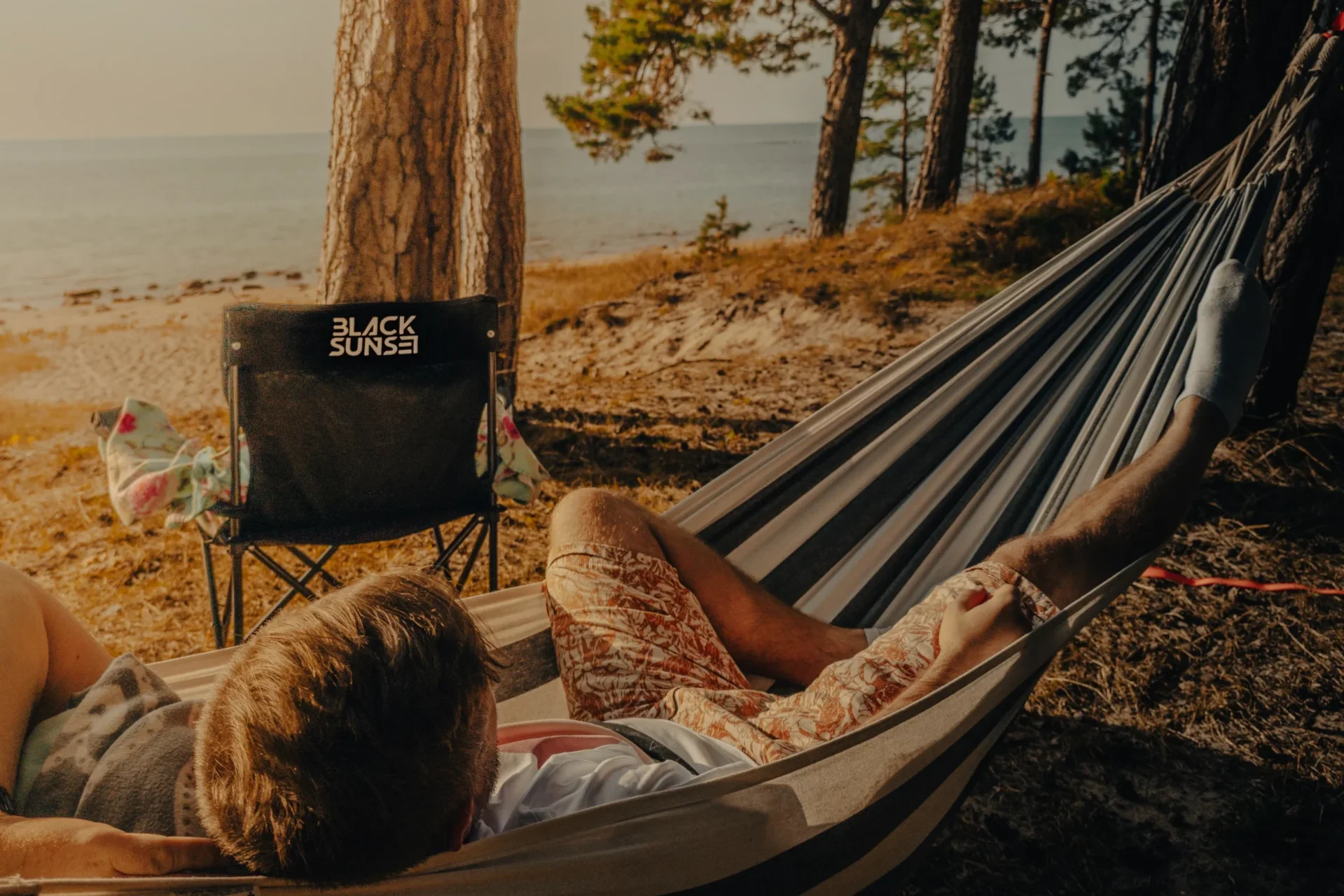 Blacksunset – Anti Soosaar võrkkiiges, rannamändide vari ja vaade merele; bränditool kaadris, aeglane ja mõtlik vibe.