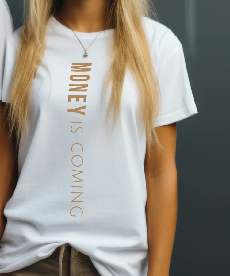 Naine valges “MONEY IS COMING” T-särgis, kuldne vertikaalne trükk; lifestyle-foto heledal taustal.