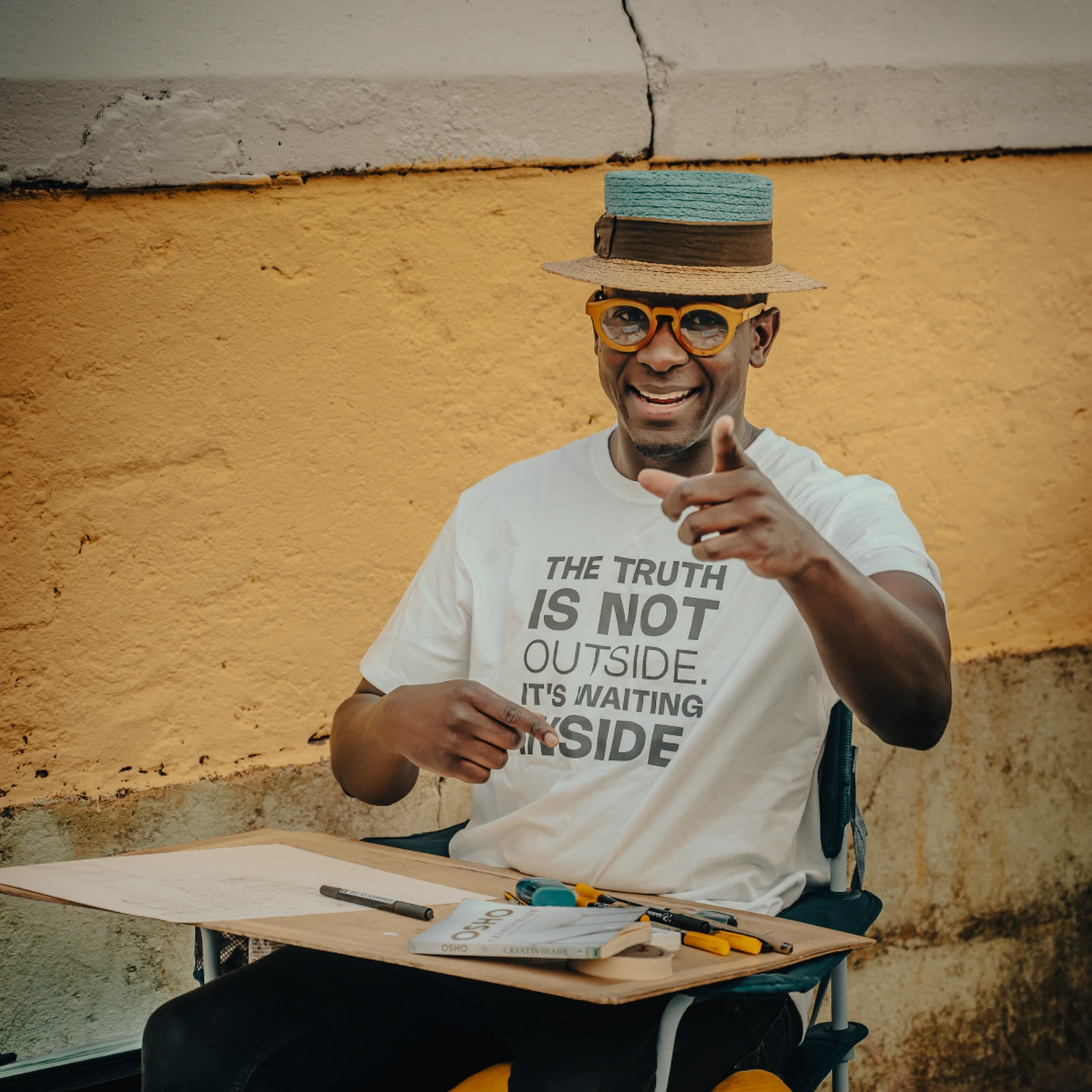 Valge T-särk kirjaga “THE TRUTH IS NOT OUTSIDE. IT’S WAITING INSIDE.” – naeratav mees, soe urban-lifestyle.