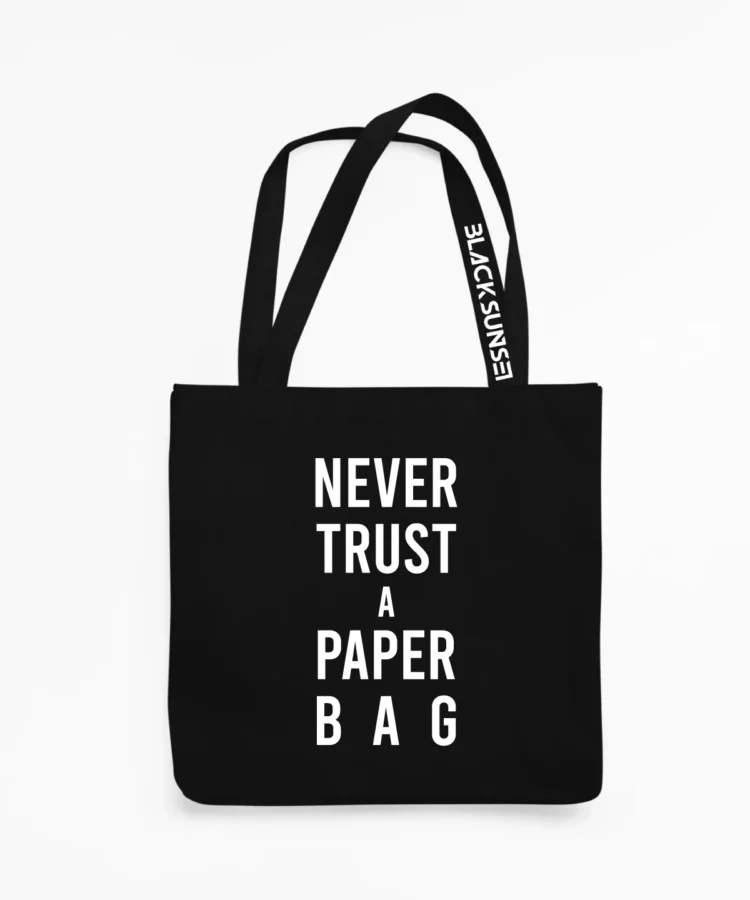 Must kangaskott valge vertikaalse kirjaga “NEVER TRUST A PAPER BAG”, esivaade; pikad sangad, sangal BLACKSUNSET trükk, tootekujutis valgel taustal.