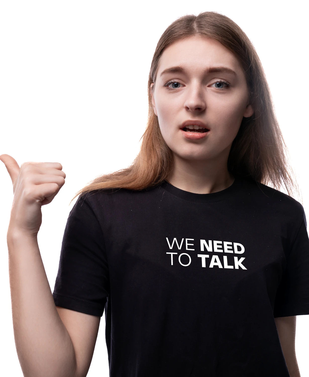 Noor naine musta “WE NEED TO TALK” T-särgiga, osutab pöidlaga vasakule; stuudiotaust, mudelifoto.