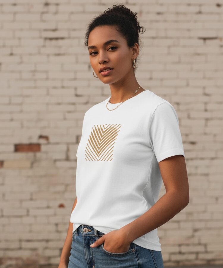 Blacksunset unisex valge T-särk „HEART STRIPE” — kuldne triibusüda ruudus; naismudel ¾ eesvaade, heleda tellisseina taust, puhas lõige.