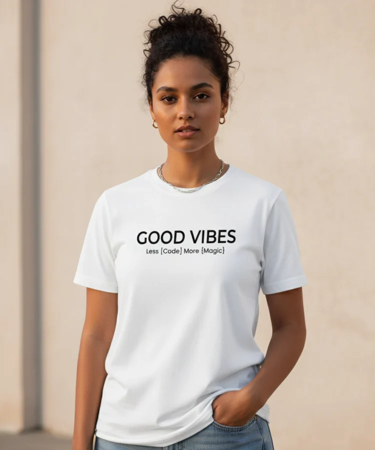 Blacksunset unisex valge T-särk GOOD VIBES – Less [Code] More {Magic}; sirge eesvaade, naismudel käsi taskus, soe õhtuvalgus, beež seintaust.