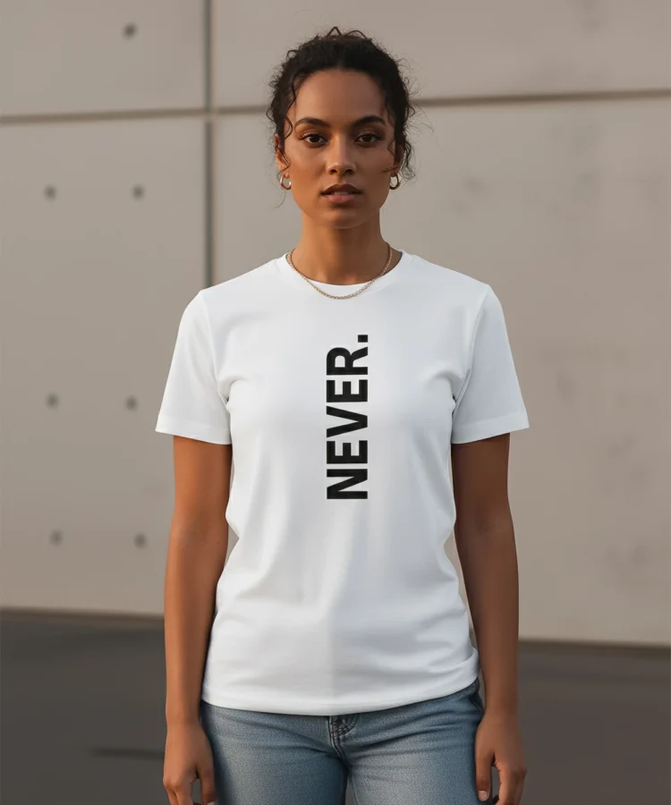 Blacksunset unisex valge T-särk „NEVER.” — sirge eesvaade; vertikaalne must kirjatrükk keskjoonel; minimalistlik stiil, betoonsein taust.