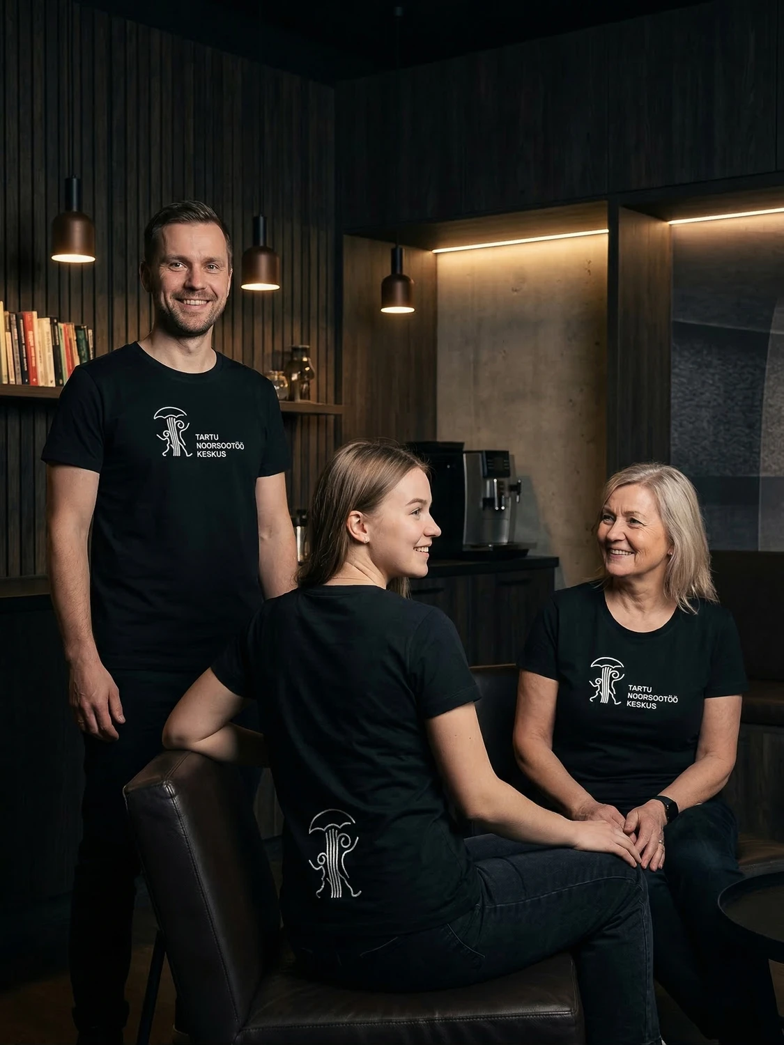Tartu Noorsootöö Keskuse liikmed logoga T-särkides lounge keskkonnas