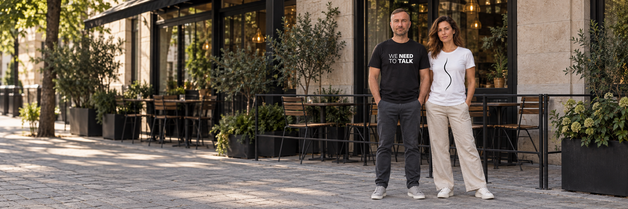 Anti and Carolina wearing Blacksunset T-shirts outside a café.