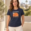 Carolina kannab tumesinist California unisex T-särki ja heledaid pükse päikeselisel kiviterrassil.