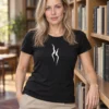 Liis wears a black women's-cut Kahekõne T-shirt with two white profiles in a library with wooden shelves.