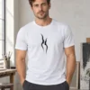 Rasmus wears a white Kahekõne unisex T-shirt in a sunlit atelier, with two opposing black profiles printed on the chest.