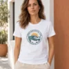 Carolina kannab valget Pärnu Surf Social Clubi linnakujundusega T-särki valge ja terrakotatooni hoone juures.