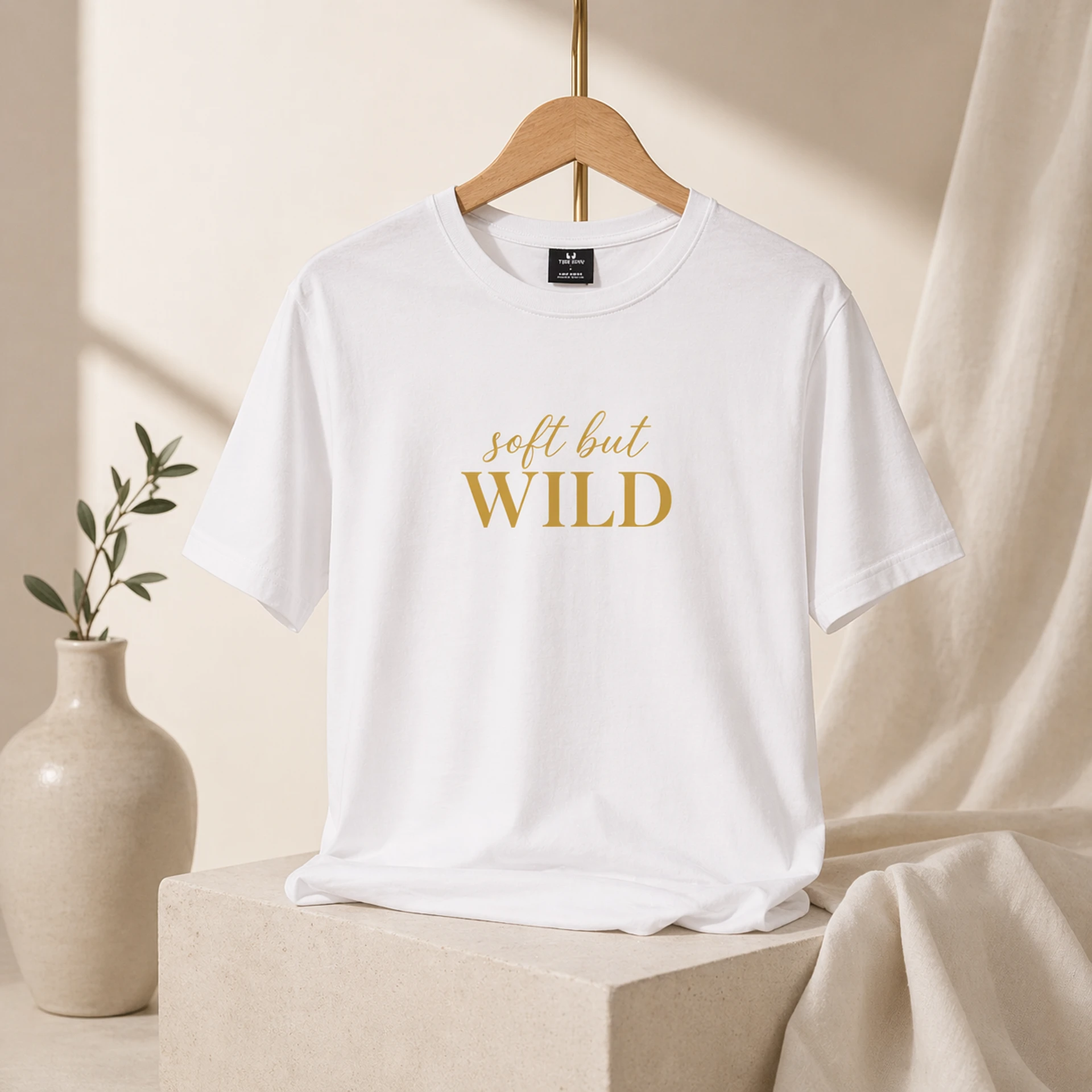 Soft But Wild valge T-särk kuldse kirjaga puhtal premium taustal
