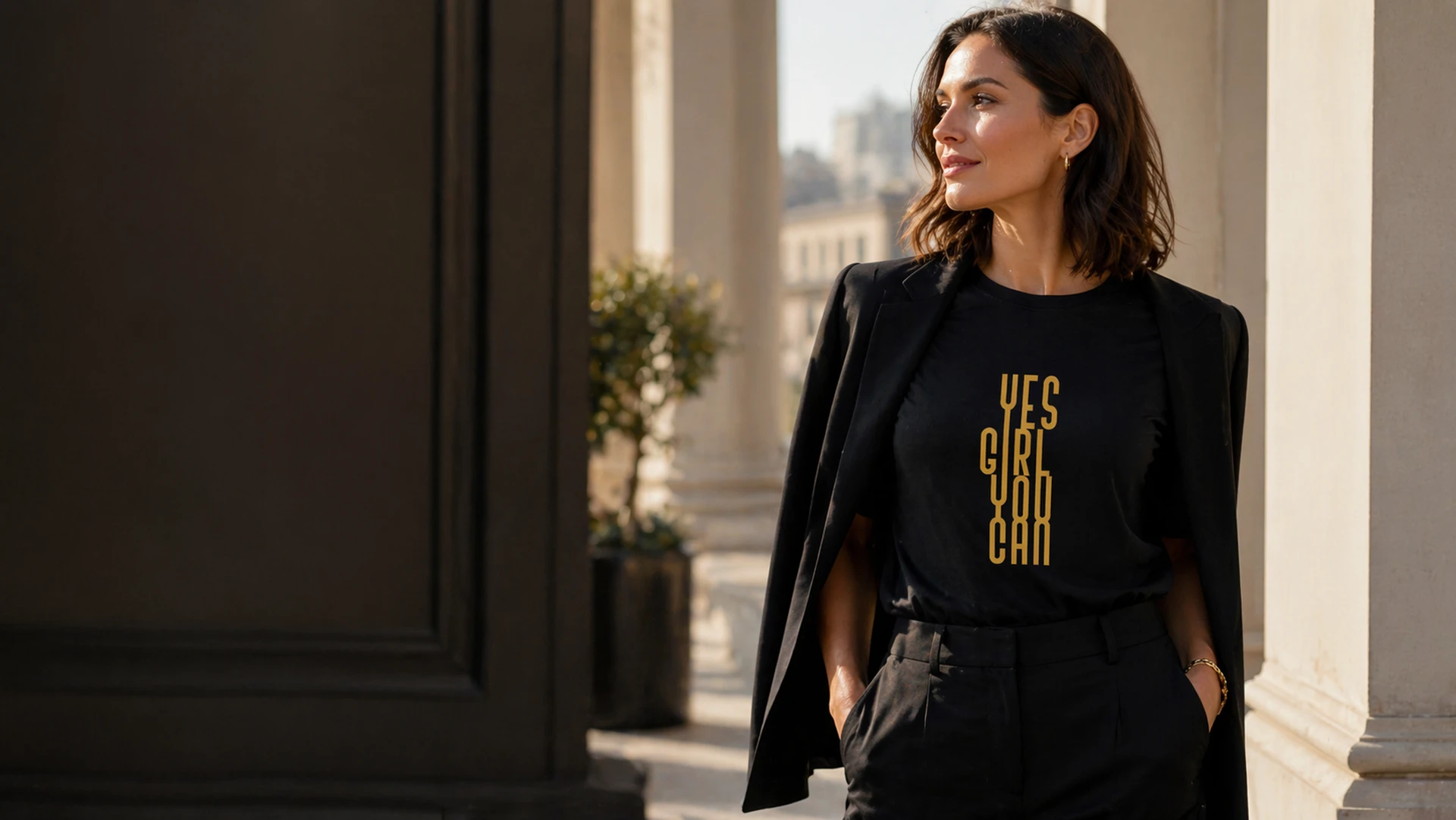 Black Yes Girl You Can T-shirt with vertical gold lettering worn under a blazer